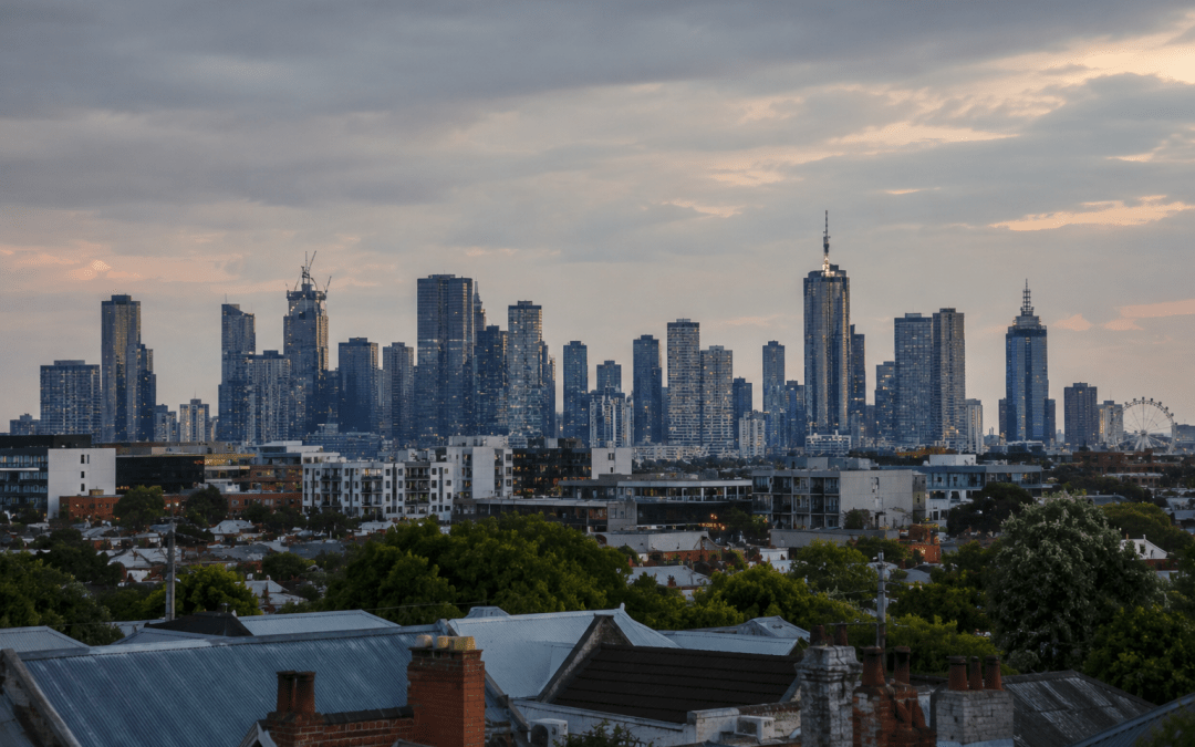 Melbourne city skyline at dusk viewed across inner-suburban rooftops